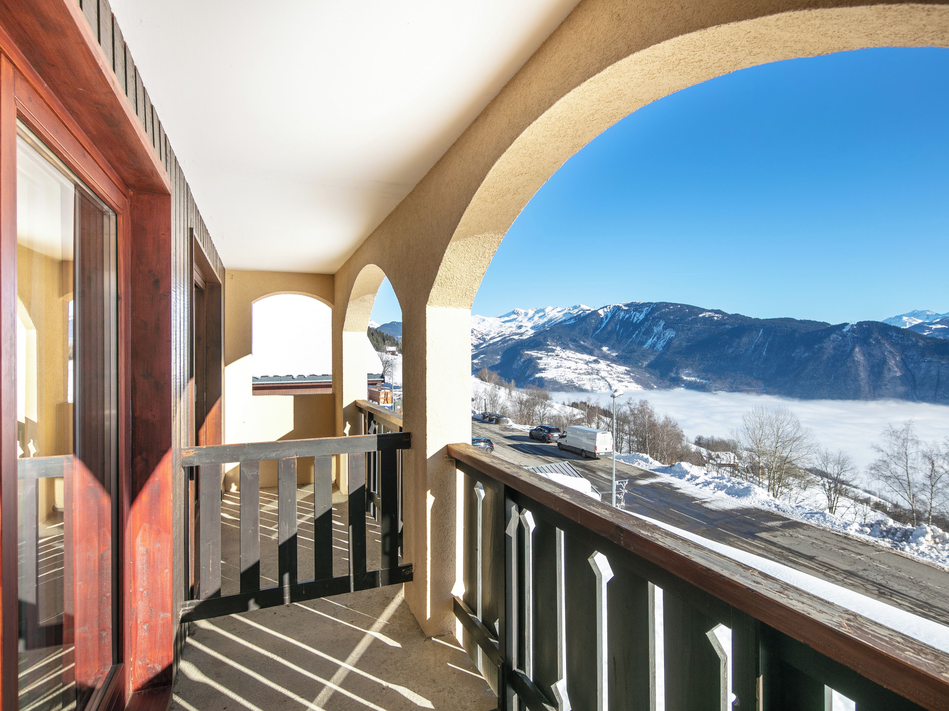 Ein Balkon mit Blick auf schneebedeckte Berge und eine Straße.