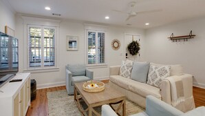 A living room with a sofa, armchairs, a coffee table, and a TV.