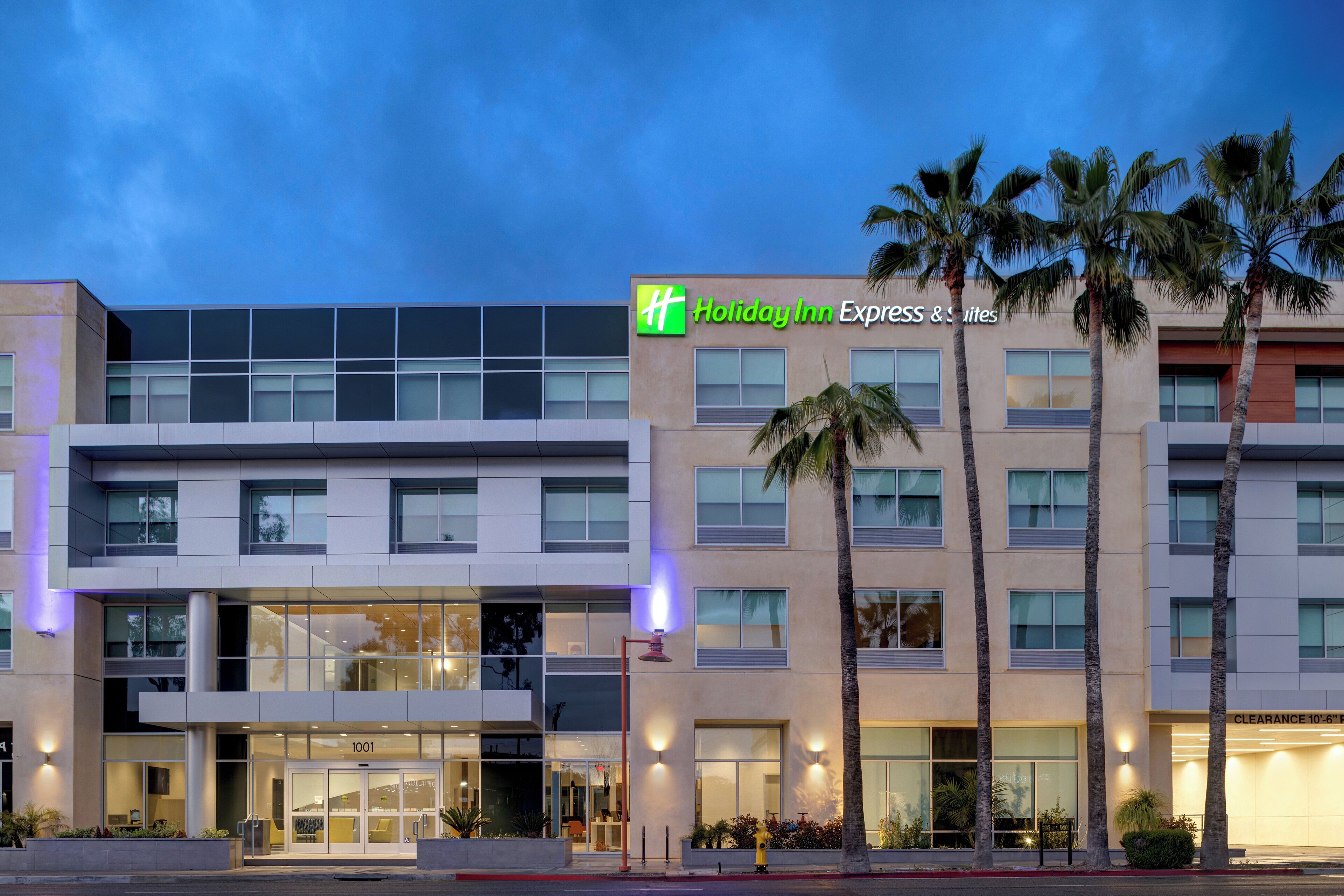 Een Holiday Inn Express & Suites gebouw met een modern ontwerp, grote ramen en een duidelijke entree.