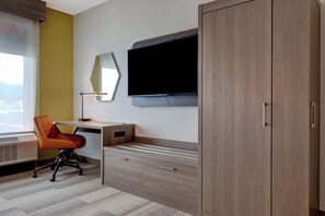 A hotel room with a desk, chair, TV, wardrobe, and a large window. - Holiday Inn Express & Suites Glendale Downtown by IHG (Glendale)