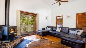 A living room with a fireplace, leather sofa, and a cowhide rug.