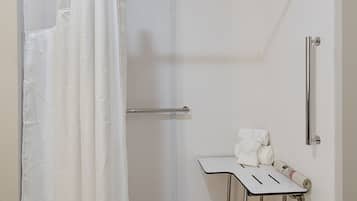 A bathroom with a shower, a toilet, and a sink.