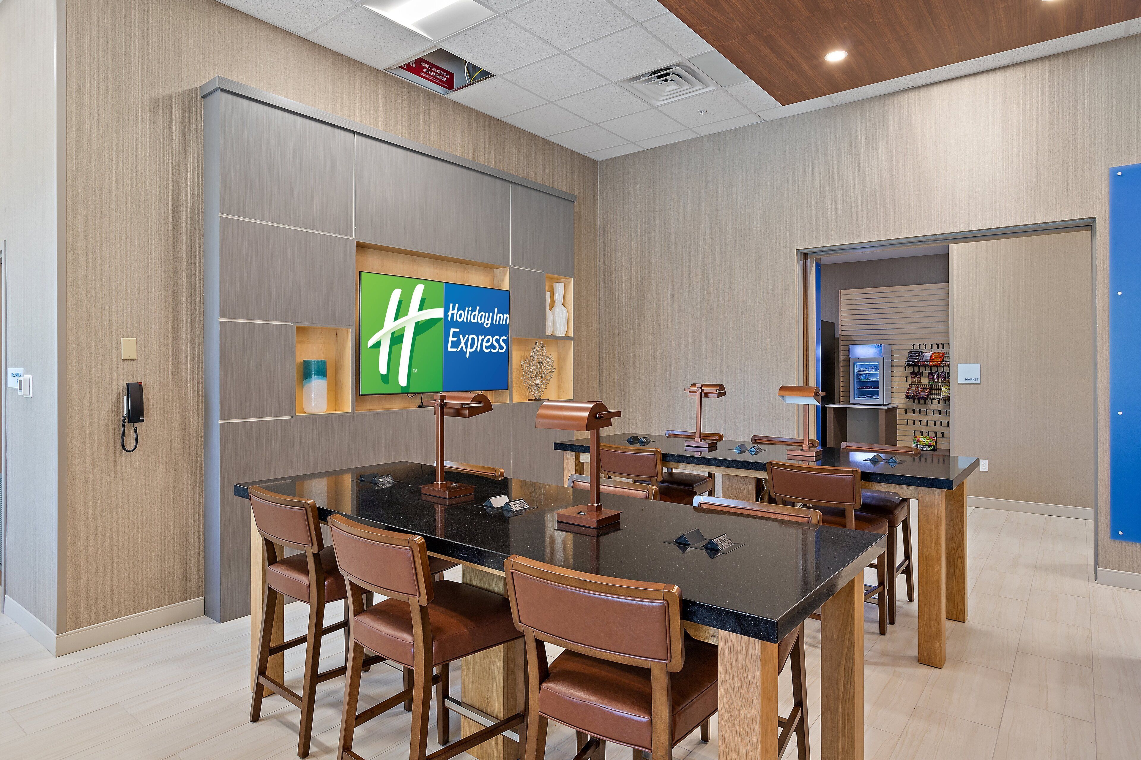 A hotel lobby with a reception desk, chairs, and a Holiday Inn Express sign.
