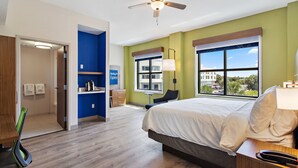 A hotel room with a bed, a desk, a chair, a window with a view, and a ceiling fan. - Holiday Inn Express St. Augustine - Vilano Beach by IHG (St. Augustine)