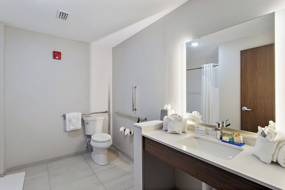 A modern bathroom with a toilet, sink, and shower.