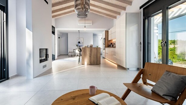 A modern interior with a wooden bench, a table with a book and a mug, and a kitchen area with a central island. - Swedish-style Villa Salz (Unknown)