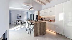 A modern kitchen with a central island, bar stools, and a dining area with a table and chairs. - Swedish-style Villa Salz (Unknown)