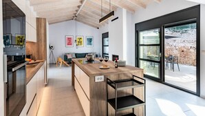 A modern kitchen with a wooden island, large windows, and a view of the outdoors. - Swedish-style Villa Salz (Unknown)