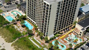 Un hôtel de grande hauteur doté de plusieurs piscines, d’une zone de plage et d’un parking.