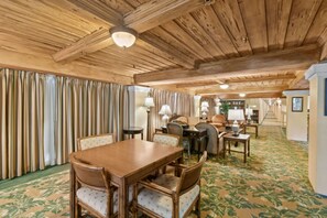 A spacious room with a wooden ceiling, a dining table with chairs, and a patterned carpet. - Condo/Pool/StepsToBeachDine/Island 1br (Palm Beach)