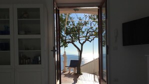 An open doorway leading to a balcony with a view of the sea, a bench, and a statue. - Little Ludovica - Panoramic terrace by the sea (Ravello)