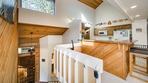 Una cocina moderna con detalles de madera, un microondas integrado y un refrigerador.