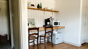 A compact kitchen with a wooden countertop, two wooden chairs, a microwave, and a small refrigerator. - Steps to VT Campus & Cassell Cozy Blacksburg Studio (Blacksburg)