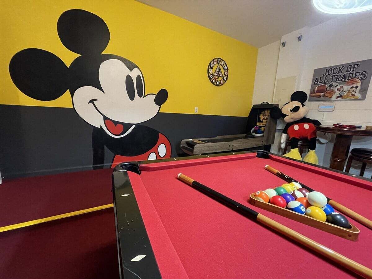 Een pooltafel met een rode viltkleed, poolkeus en ballen.