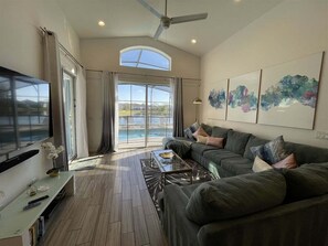 A living room with a sofa, TV, and artwork.