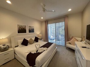 Une chambre d’hôtel avec un lit, des tables de chevet, un bureau et une vue sur l’extérieur.