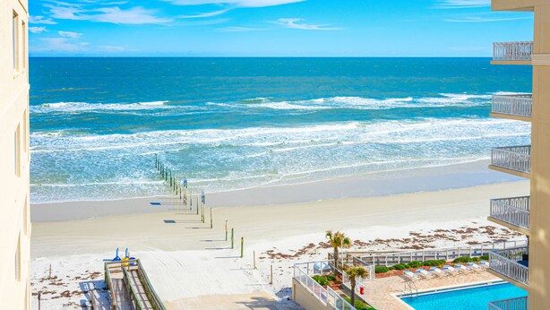 Een strandhotel met zwembad, toegang tot het strand en uitzicht op de oceaan.