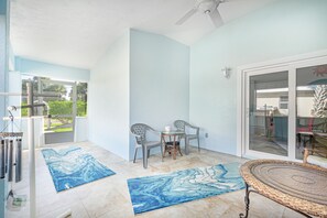 A spacious patio with two chairs, a table, and a ceiling fan. - Beach-side Pool Home - Hope's Haven (Port Orange)