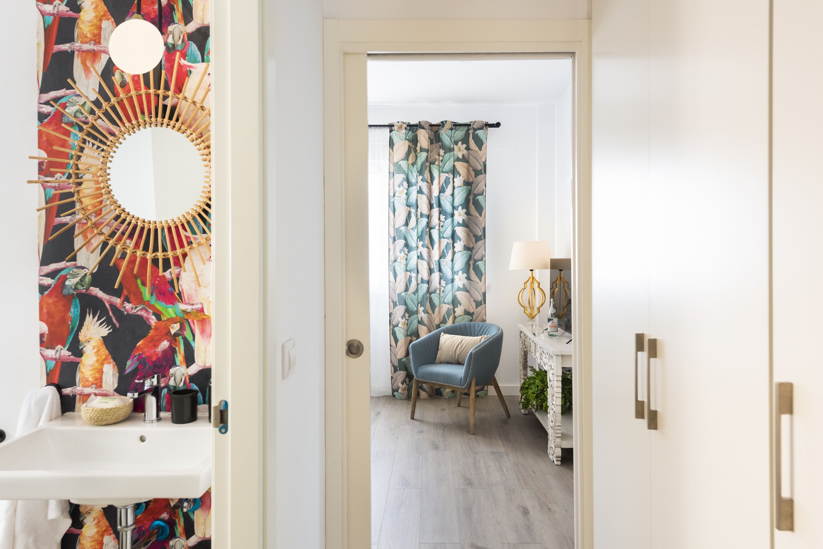 A bathroom with a sink, mirror, and decorative wall.