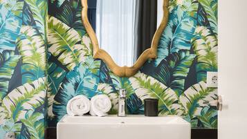 Une salle de bain avec un lavabo, un miroir et des serviettes.