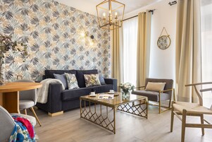 Dúplex, vistas a la ciudad, planta baja | Zona de estar | Televisión de pantalla plana de 50 pulgadas con canales digitales