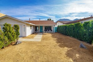 A residential property with a covered patio, a garage, and a well-maintained lawn.