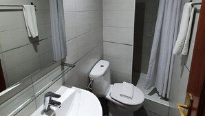 A modern bathroom with a white sink, toilet, and shower. - LM Rooms Opera (Madrid)