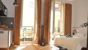 Ein Zimmer mit Bett, Schreibtisch und einem fensterbepflanzten Fenster.