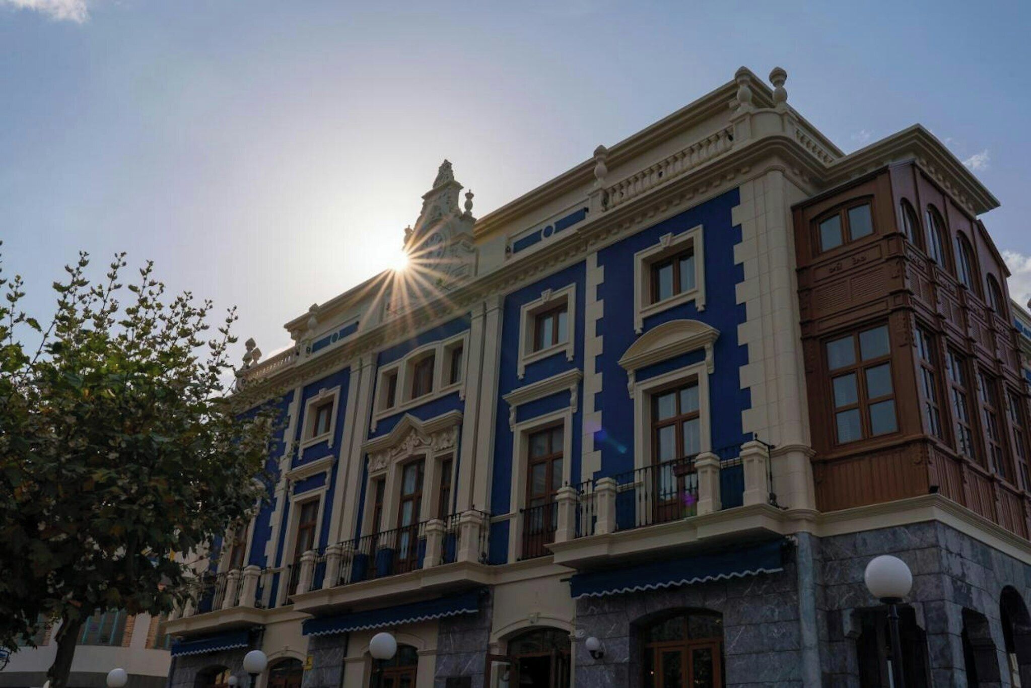 Un edificio clásico con arquitectura simétrica, ventanas grandes y una entrada central destacada.