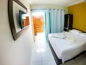 A hotel room with a bed, a TV, a wardrobe, and a bathroom visible through a door. - Pousada Porto Maraca (Ipojuca)