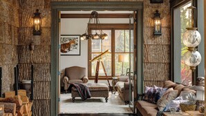 A cozy interior with a fireplace, a sofa, and a dining area.