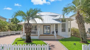 A single-story house with a covered porch, a small front yard with a palm tree, and a white picket fence. - Pet-Friendly | Steps to Beach | Pool (Destin)