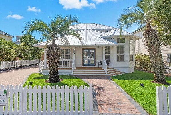 A single-story house with a covered porch, a small front yard with a palm tree, and a white picket fence. - Pet-Friendly | Steps to Beach | Pool (Destin)