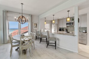 Una cocina amplia con una isla grande, electrodomésticos modernos y vistas a la playa.
