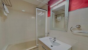 Ein Badezimmer mit Badewanne, Waschbecken und Spiegel.