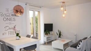 A modern living room with a dining area, a flat-screen TV, and a statement wall with a quote. - Edificio Privado La Herradura (Haro)