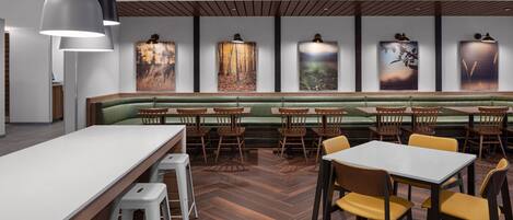 A restaurant with a long counter, booths, and tables.