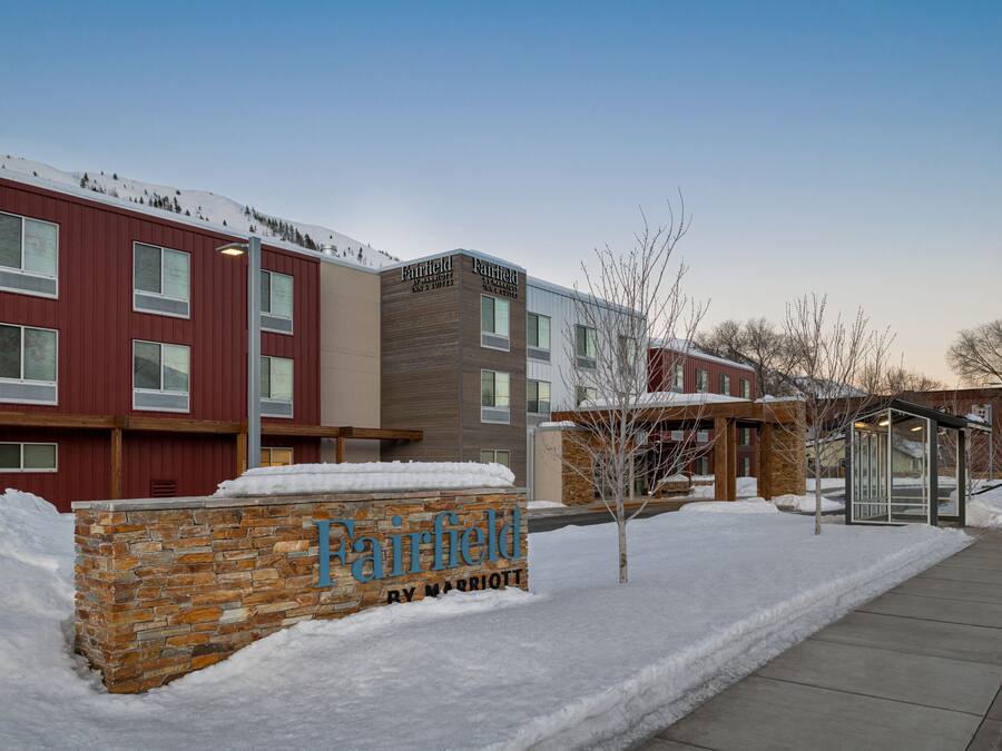 A Fairfield by Marriott hotel with a stone facade, multiple windows, and a snow-covered ground.
