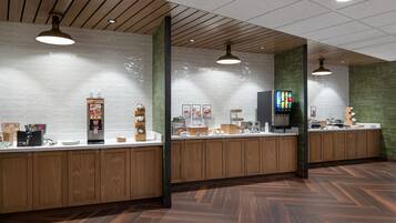 Un espace cuisine moderne avec des meubles en bois, un plan de travail blanc et un sol Ă motifs en chevrons.