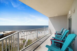 A balcony with a view of the beach and ocean.