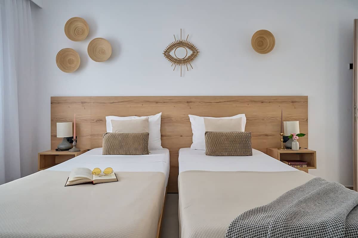 Une chambre double avec deux lits, chacun doté d’une table de chevet, de lampes et d’œuvres d’art décoratives sur les murs.