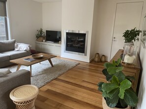 Relax in this stylish living room with a comfortable sofa, fireplace, and large TV.