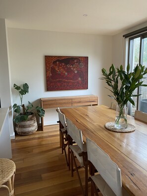 Enjoy meals with family and friends at this dining area, featuring a long table and comfortable chairs.