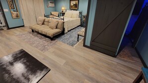 A bedroom with a bed, a sofa, a small table, and a mirror. - Alpine •air•B&B- A Charming •air•B&B in Downtown Helen, GA! (Helen)