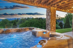 A hot tub with a stone pillar and a view of mountains and trees. - 6BR/4.5BR Retreat: Views, Pool, HotTub, Sauna & Game-room (Leicester)