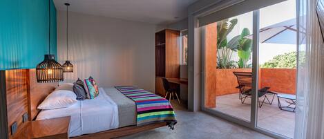 Une chambre moderne avec un grand lit, un bureau et une vue sur l’extérieur.
