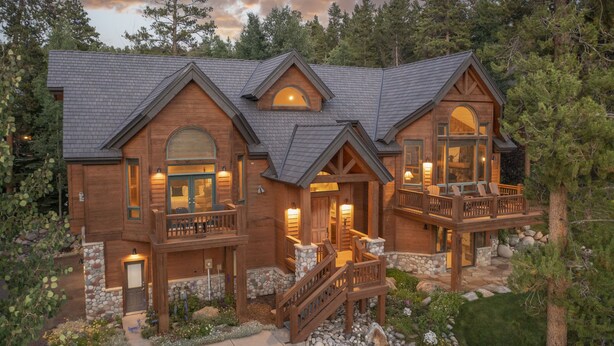 A large, multi-story wooden house with a stone foundation, a balcony, and a stone staircase. - Walking distance to downtown Breck, Stunning ski resort panorama, hot tub, foosball, arcade machine! (Breckenridge)