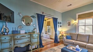 Un soggiorno con parete blu, divano beige, tavolino in legno e tenda blu.
