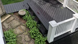 Eine Terrasse mit einem roten Sonnenschirm, einem Tisch und Stühlen.