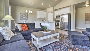 A modern living room with a gray sofa, a coffee table, and a patterned rug. - Washington Townhome w/ Patio + Resort Perks! (Washington)